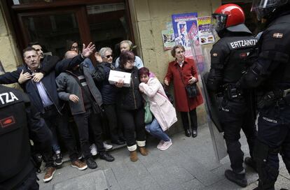 Un grupo de personas frente a agentes de la Ertzaintza después del mitin de Ciudadanos.