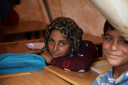Dos niños asisten a una de las clases en la escuela 'Zuhur al-Mustaqbal, en la localidad de Atme (Siria).