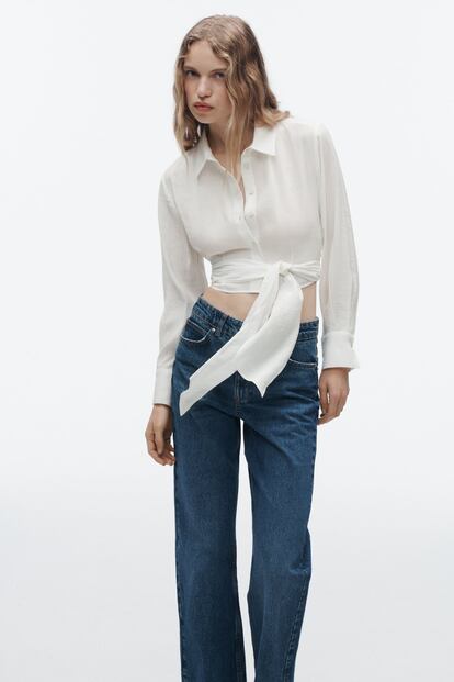 La versión más femenina y sofisticada de la camisa clásica blanca bien podría ser esta de Zara, cortada por encima del ombligo y con una gran lazada cruzando la cintura.

22,95€