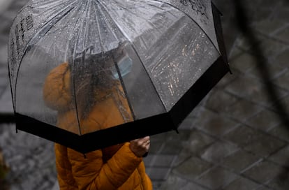 Una persona camina bajo la lluvia protegida con un paraguas, este jueves en Madrid.