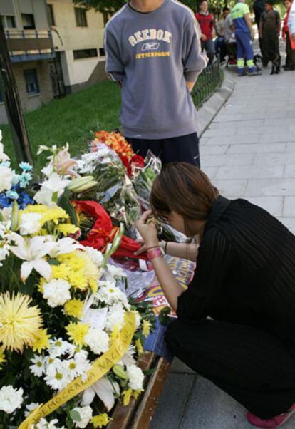 Una joven deposita flores junto al lugar donde se produjo el asesinato que desencadenó los incidentes.