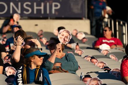 A fan protects herself from the sun at a women's soccer game in San Diego, California, in November 2023. 