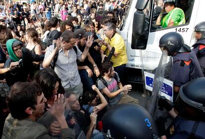 La policía trata de abrir paso a un camión de basura tras haber limpiado la Plaza de Cataluña.