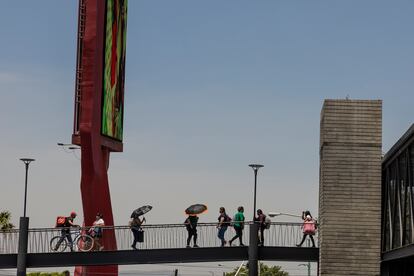 Personas caminan con sombrillas en la estación Periférico Sur del Tren Ligero de Guadalajara (Jalisco), el 15 de junio.
