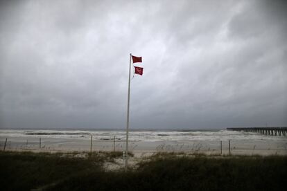 La bandera roja puesta sobre la playa alerta a los turistas sobre el peligro en el mar.