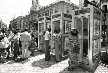 Usuarios de cabinas telefónicas esperan en la Puerta del Sol de Madrid en 1985