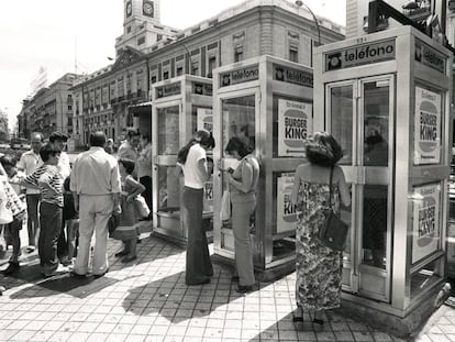 Usuarios de cabinas telefónicas esperan en la Puerta del Sol de Madrid en 1985