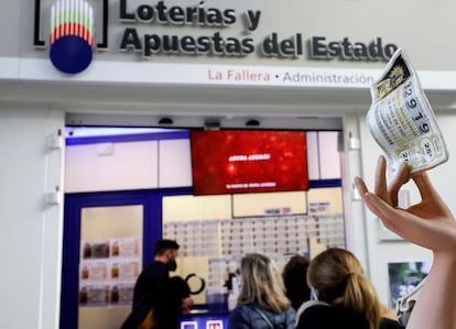 Varias personas guardan cola para adquirir la lotería de Navidad en Valencia, el pasado fin de semana.