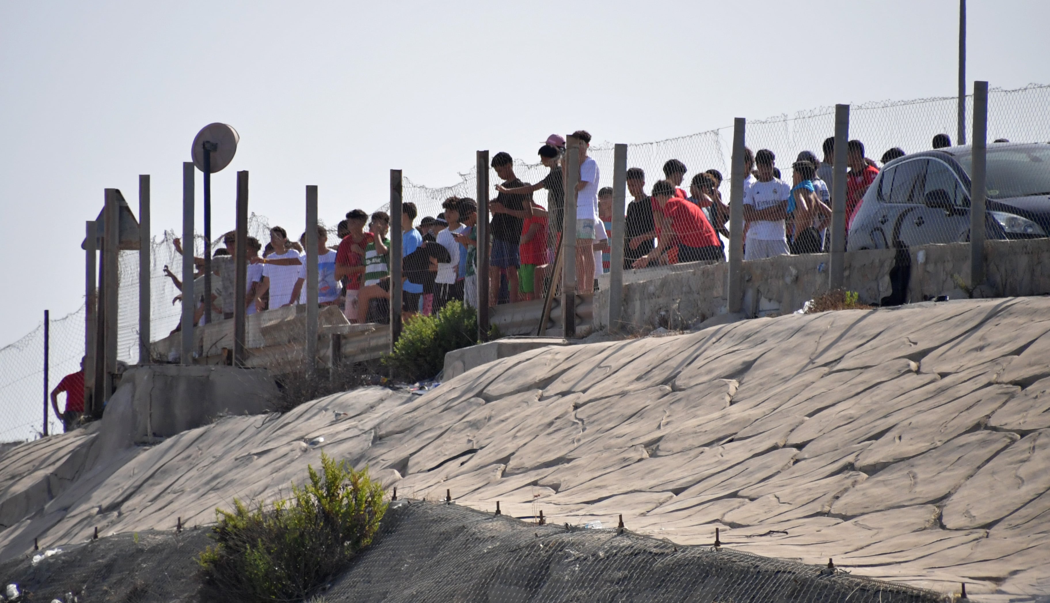 Los menores acogidos por la ciudad miran la playa y la frontera desde lo alto del Tarajal.