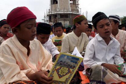 Niños musulmanes leen el Corán durante una ceremonia celebrada en Banda Aceh en favor de la paz.