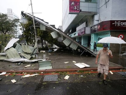 Un hombre pasa junto a un edificio dañado por el tifón Soudelor, en Taipei, este sábado.