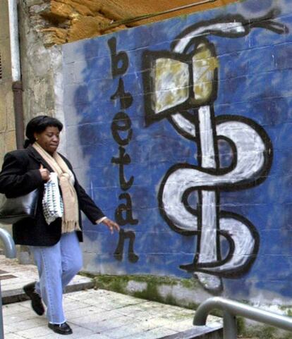 Una mujer pasa delante de una pintada de ETA en una calle de Eibar.
