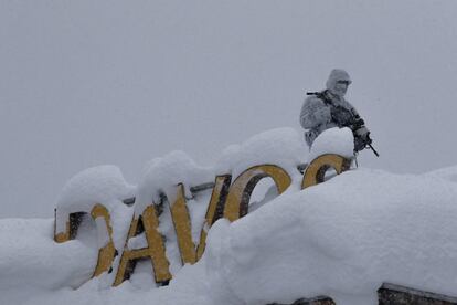 Un oficial de policía suizo armado hace guardia en el techo de un hotel cerca del bloque donde tiene lugar la reunión anual del Foro Económico Mundial en Davos (Suiza).