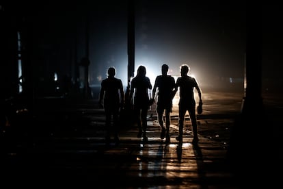 A group of people walk down a street during a blackout on Sunday, in Havana.