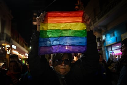 A woman raises a flag of the LGBTQI+ community during the mobilization called after the triple lesbicide.