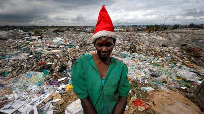 Una joven con gorro de Santa Claus posa delante del vertedero de Dandora, en Nairobi, Kenia.