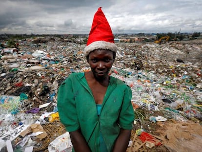 Una joven con gorro de Santa Claus posa delante del vertedero de Dandora, en Nairobi, Kenia.