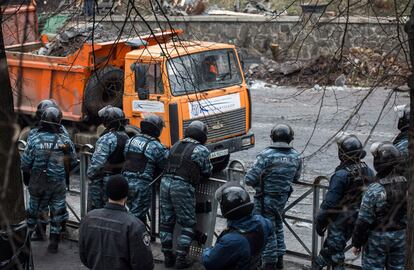 A mediados de enero, tras dos meses con el centro de Kiev tomado permanentemente por miles de manifestantes opositores, el Gobierno aprobó una serie de leyes represivas que fueron respondidas con violencia por los manifestantes más radicales. En la imagen, la policía antidisturbios contempla los trabajos para retirar las barricadas en Kiev (Ucrania).