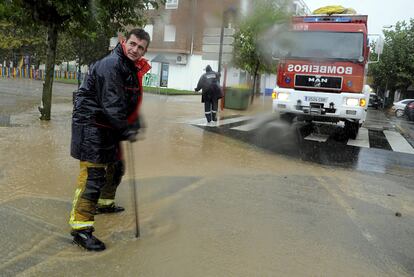 Varios bomberos achican agua de una calle inundada por el temporal en Vilagarca de Arousa, Pontevedra.