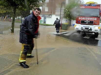 Varios bomberos achican agua de una calle inundada por el temporal en Vilagarcía de Arousa, Pontevedra.