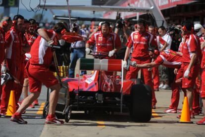 Fernando Alonso rodeado de mecánicos de Ferrari en los entrenamientos de ayer.
