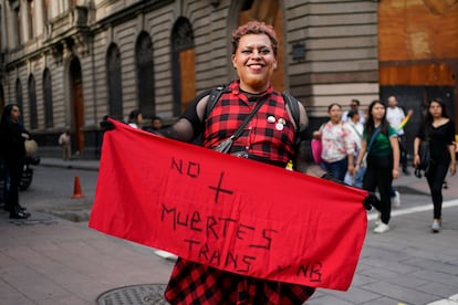 Una persona muestra una pancarta con el mensaje "No más muertes trans" durante el desfile anual del orgullo.