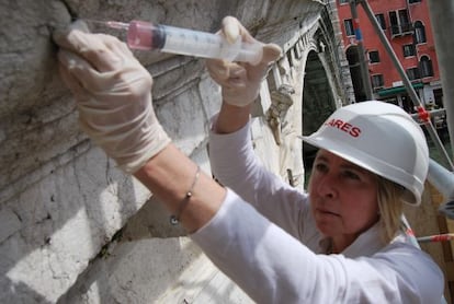 La restauradora Elisabetta Ghittino, inyecta alcohol en una piedra dañada del puente de Rialto.