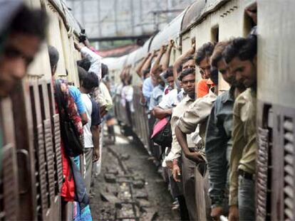 Pasajeros a bordo de dos trenes de cercanías en plena hora punta, ayer en Bombay.