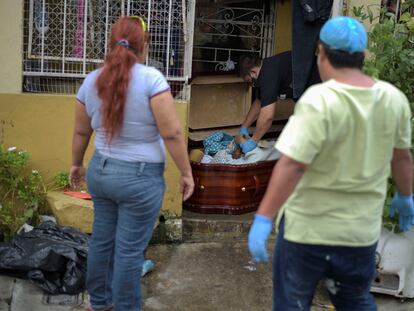 Uma mulher observa um caixão com o cadáver da sua mãe, morta pela Covid-19, na terça-feira em Guayaquil.