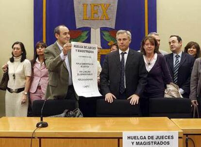 El juez de Madrid Benito Raboso exhibe un cartel de protesta junto a otros magistrados.