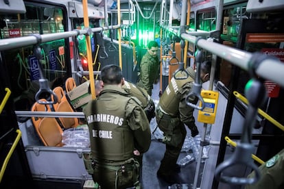 Efectivos de Carabineros ayudan en la entrega de alimentos y agua a los cientos de pasajeros que quedaron en la noche de este domingo y la madrugada del lunes atrapados en la zona del aeropuerto, tras la cancelación de sus vuelos debido al toque de queda decretado en la capital chilena por las violentas protestas ocurridas en la capital en los últimos tres días.