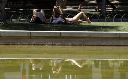 Unas chicas toman el sol en una fuente de la Plaza de España, 5 de julio de 2013.