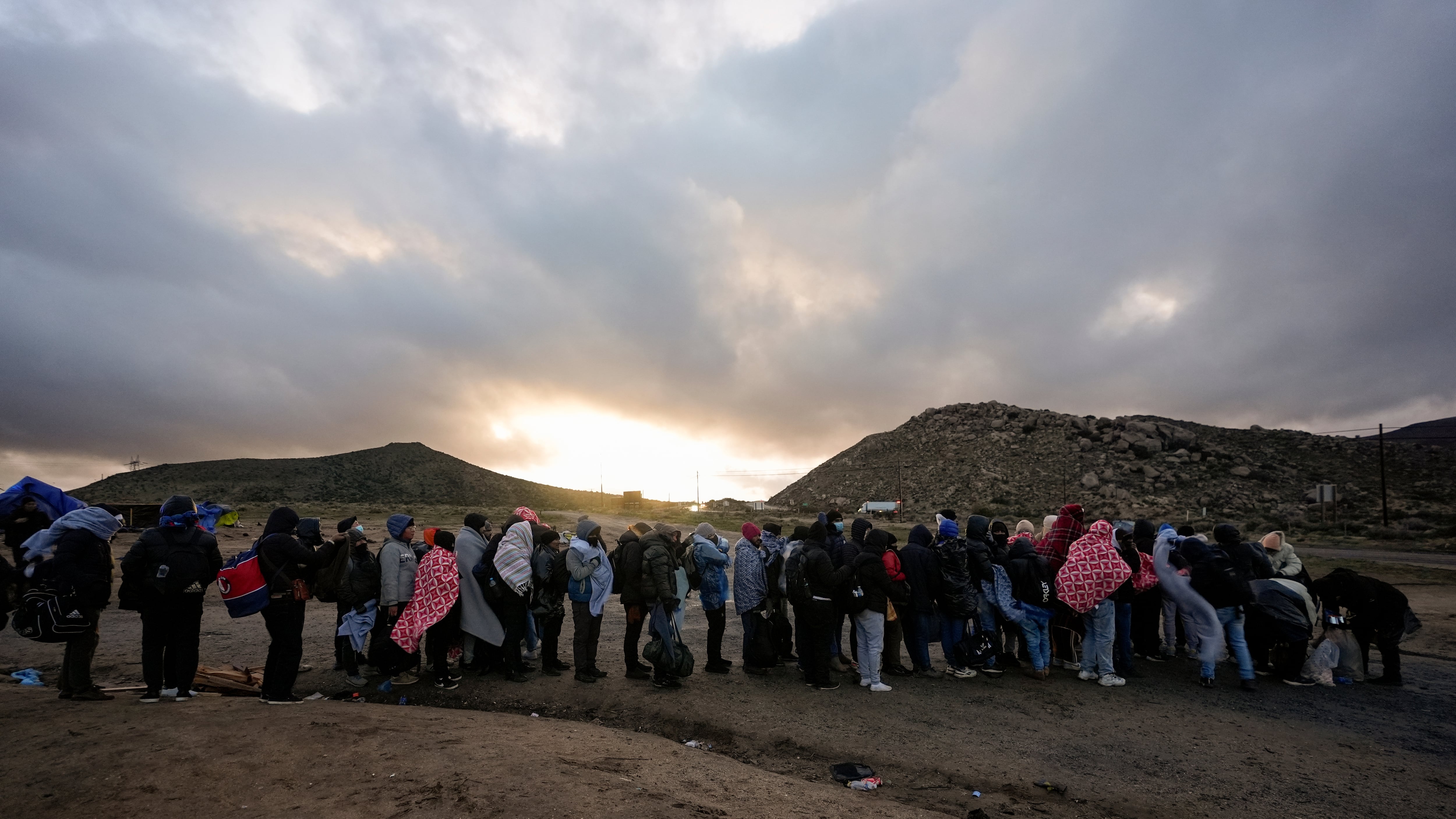 Un grupo de migrantes espera para ser deportados en la zona de Hot Springs, California, en febrero de 2024.