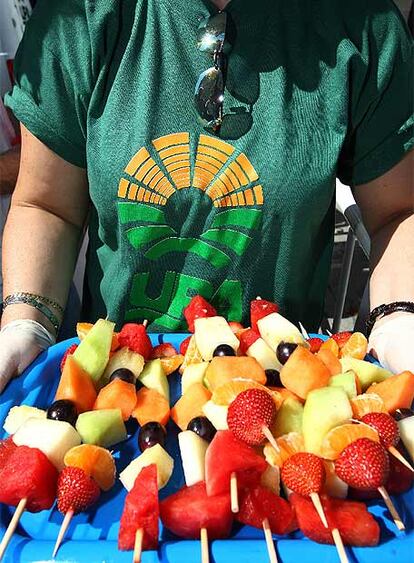 Una mujer de la UPA reparte pinchitos de fruta frente al Reina Sofía.