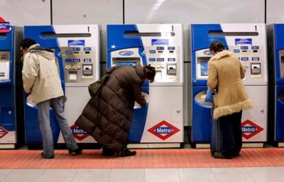 Usuarios de Metro adquiriendo su billete en máquinas automáticas.