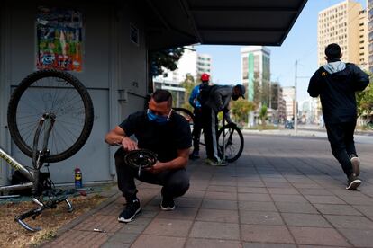 Migrantes venezolanos reparan bicicletas en las calles de Quito, Ecuador.