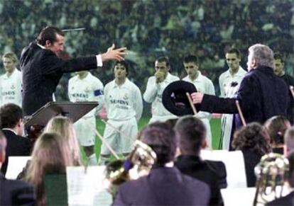 José María Cano dirige a Plácido Domingo, que canta el himno del Madrid ante la plantilla blanca.