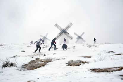 Um grupo de jovens brinca junto aos molinhos de vento do Campo de Criptana (Cidade Real).