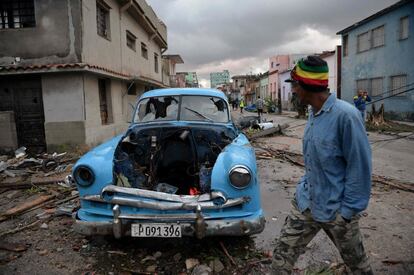 O tornado surgiu de uma esperada tempestade que já afetava a zona oeste de Cuba, com ventos de até 100 quilômetros por hora. Na imagem, um homem passa ao lado de um carro destroçado pelo tornado, em Havana.