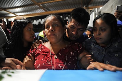 Familiares del difunto migrante Francisco Rojche Chiquival, quien murió durante un incendio en un centro de detención de migrantes en la ciudad fronteriza mexicana de Ciudad Juárez, junto a su ataúd durante un velorio en Nahualá (Guatemala), el 12 de abril de 2023.