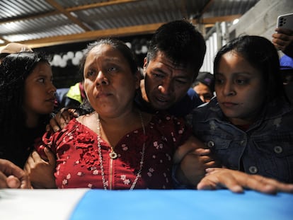 Familiares del difunto migrante Francisco Rojche Chiquival, quien murió durante un incendio en un centro de detención de migrantes en la ciudad fronteriza mexicana de Ciudad Juárez, junto a su ataúd durante un velorio en Nahualá (Guatemala), el 12 de abril de 2023.