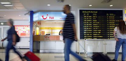 Pasajeros caminan frente a una oficina de TUI en el aeropuerto de Berlín.