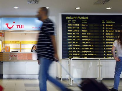 Pasajeros caminan frente a una oficina de TUI en el aeropuerto de Berlín.