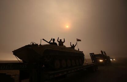 Fuerzas iraquíes haciendo el signo de la victoria subidos a un vehículo de combate, en la zona de Al-Shura, al sur de Mosul (Irak).