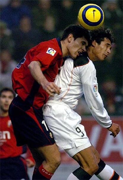 El jugador de Osasuna José Romero <i>Josetxo</i> lucha por el balón con el delantero del Valencia Bernardo Corradi.