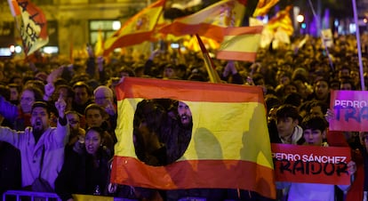 Un hombre sostiene una bandera de España sin escudo frente a la sede del PSOE en la calle Ferraz de Madrid, este jueves. 