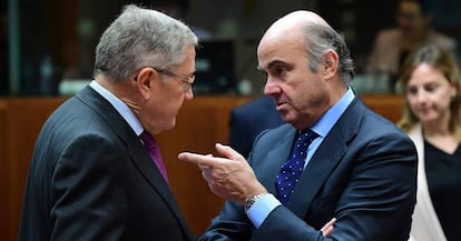 El ministro de Economía, Luis de Guindos, conversa con el director del MEDE en Bruselas.