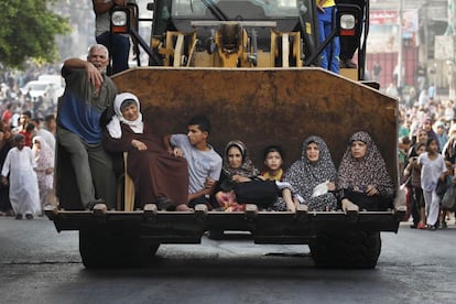 Milhares de pessoas abandonam o bairro de Shiyahiya, no leste da Faixa de Gaza, alvo de intensos e repetidos bombardeios do Exército israelense por terra e ar. Na imagem, uma família foge de Gaza em uma escavadeira, em 20 de julho de 2014.