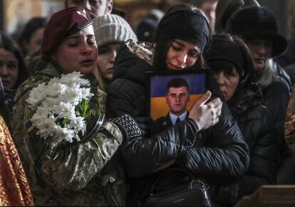 Una mujer abraza la foto de un soldado ucranio muerto en el frente, durante un funeral por tres de ellos en la iglesia de los Apóstoles Pedro y Pablo, en Lviv, el 9 de marzo.