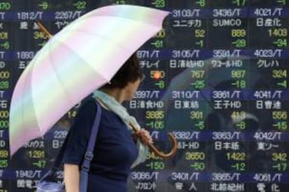 Una mujer observa la información bursátil en una pantalla informativa en Tokio.